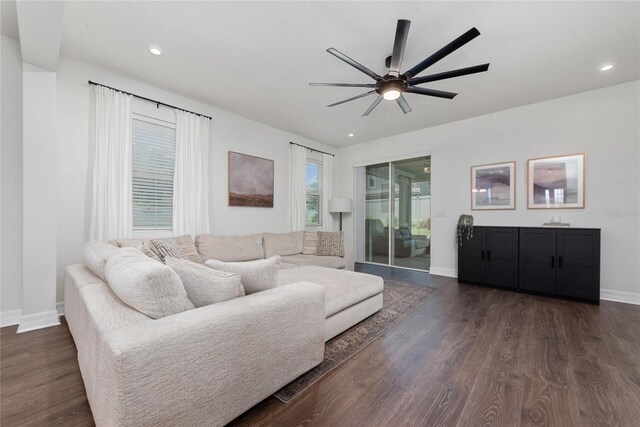 living room featuring ceiling fan and dark hardwood / wood-style flooring