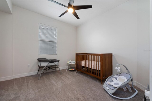 bedroom with carpet, a nursery area, and ceiling fan