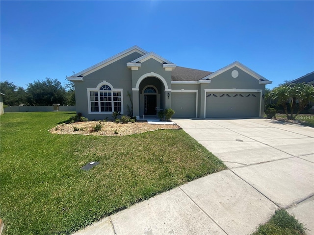 single story home with concrete driveway, a front yard, an attached garage, and stucco siding