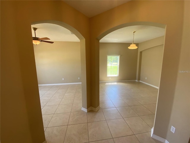 spare room featuring ceiling fan and light tile floors