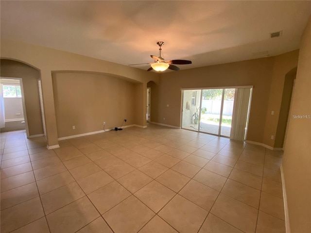 spare room featuring baseboards, visible vents, a ceiling fan, and light tile patterned flooring