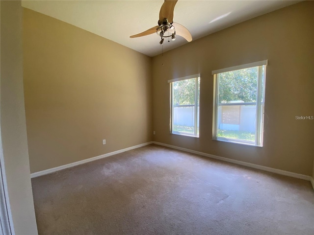 unfurnished room featuring carpet flooring, a ceiling fan, and baseboards