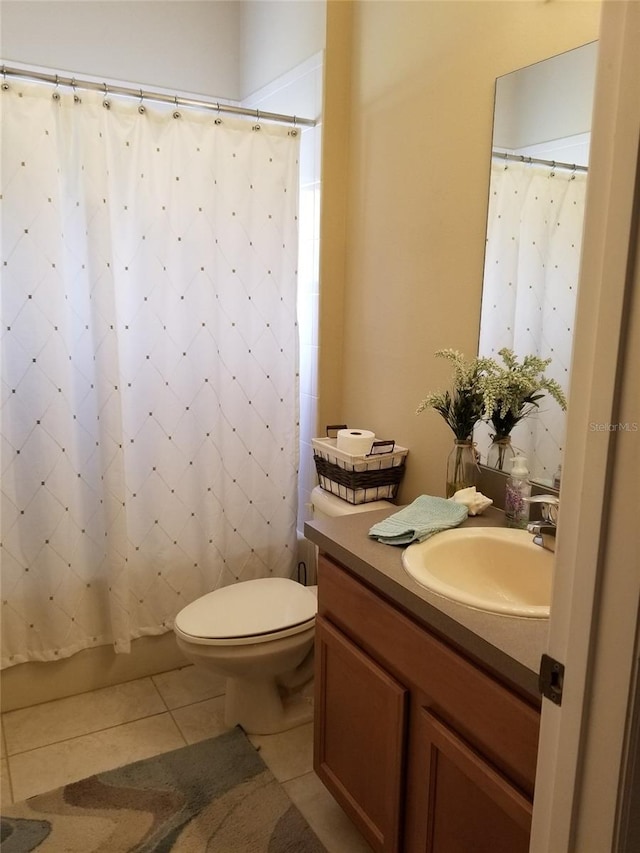 bathroom with tile flooring, oversized vanity, and toilet