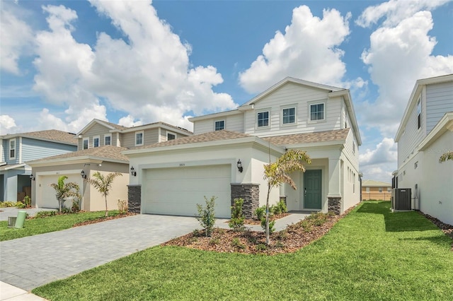 view of front of home with a garage, central AC, and a front lawn