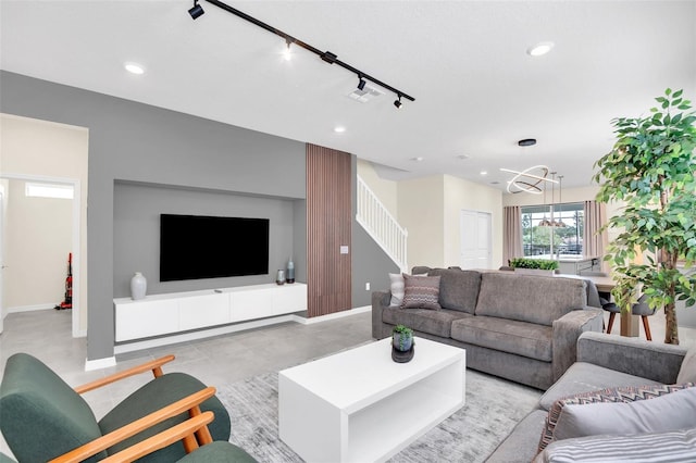 living room featuring rail lighting and a notable chandelier