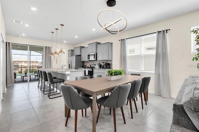 dining space featuring sink and a notable chandelier