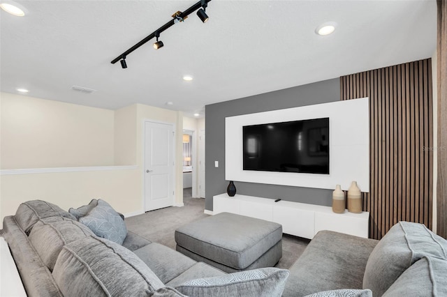 carpeted home theater room featuring track lighting