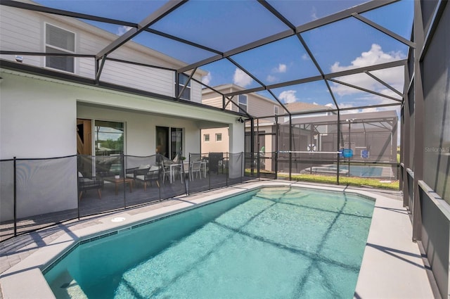 view of pool featuring glass enclosure and a patio area