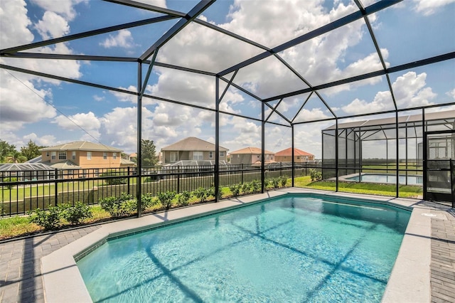 view of swimming pool featuring a patio area and glass enclosure