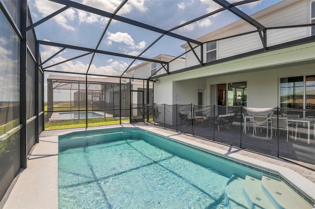 view of pool with a patio and glass enclosure