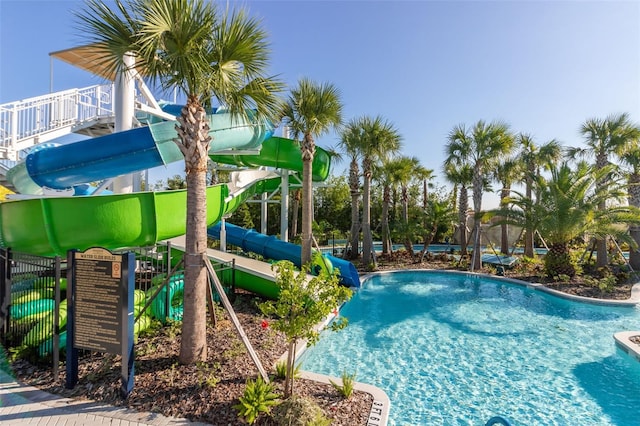 view of swimming pool featuring a playground and a water slide