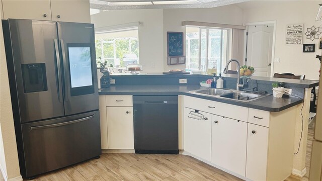 kitchen with stainless steel refrigerator with ice dispenser, dishwasher, a wealth of natural light, white cabinetry, and sink