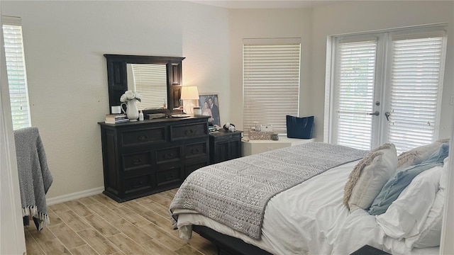 bedroom featuring french doors, multiple windows, and light hardwood / wood-style flooring