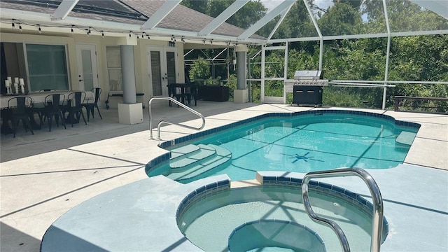 view of pool featuring a patio, a lanai, and an in ground hot tub