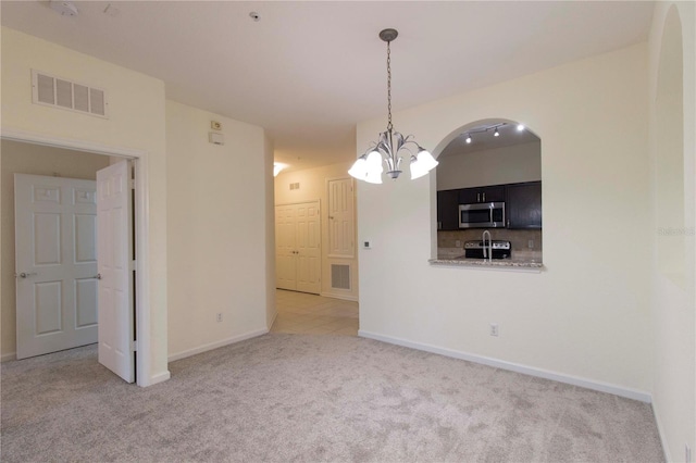 interior space featuring light carpet and a chandelier