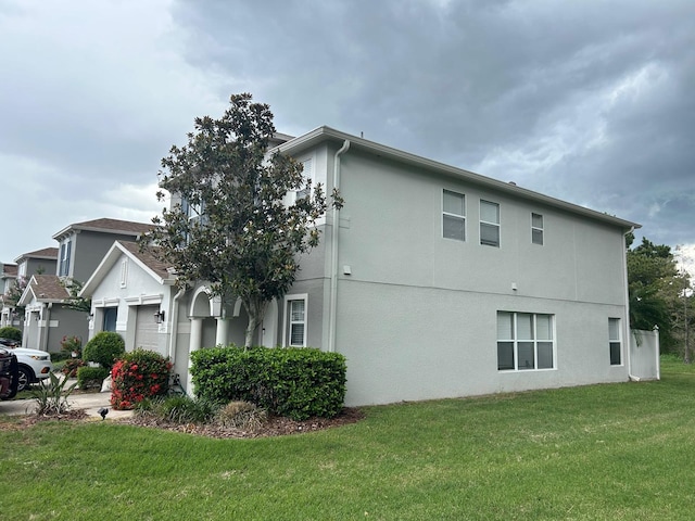 view of property exterior with a garage and a lawn