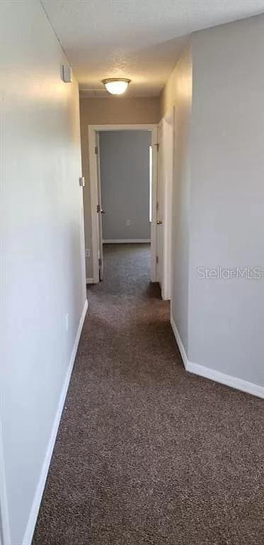 corridor featuring dark carpet