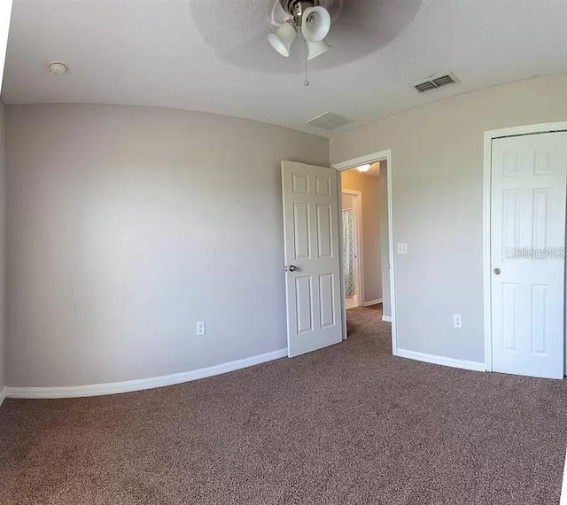 unfurnished bedroom featuring dark carpet and ceiling fan