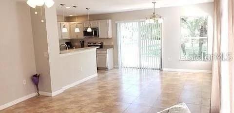 kitchen featuring white cabinets, hanging light fixtures, a chandelier, and light tile floors