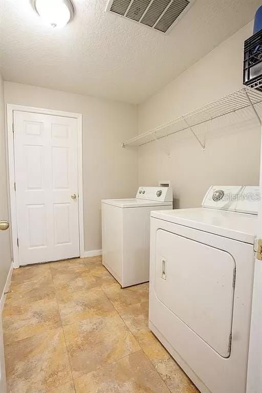 washroom featuring independent washer and dryer and light tile floors