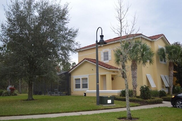 view of front of home with a front yard and central AC unit