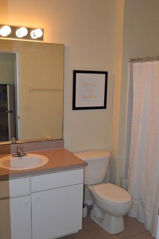 bathroom with toilet and vanity with extensive cabinet space