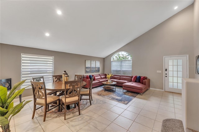 dining area with light tile patterned flooring and high vaulted ceiling