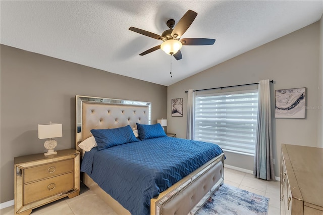 tiled bedroom featuring a textured ceiling, ceiling fan, and vaulted ceiling