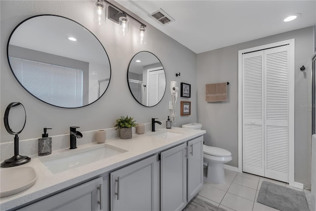 bathroom with tile patterned flooring, vanity, and toilet