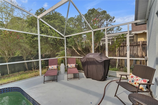 view of patio with a grill and glass enclosure