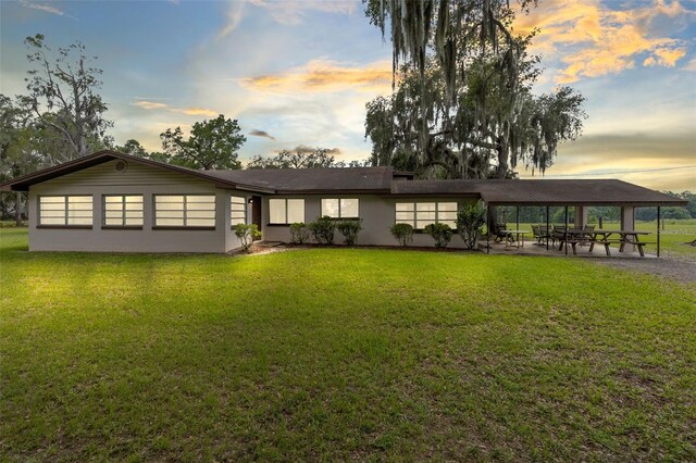 single story home with a patio area and a lawn