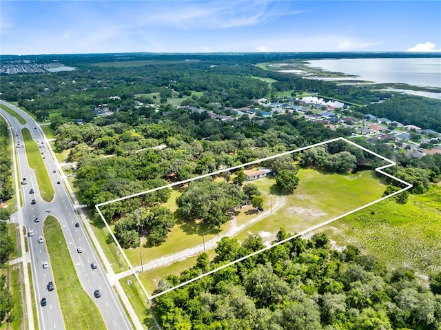 birds eye view of property with a water view and a view of trees