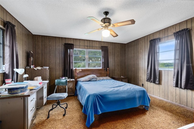 bedroom with light carpet, wood walls, multiple windows, and a textured ceiling