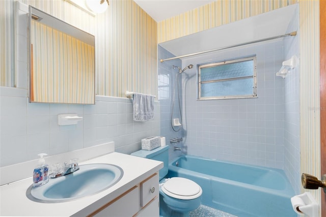 bathroom with vanity, tile walls, toilet, and wallpapered walls