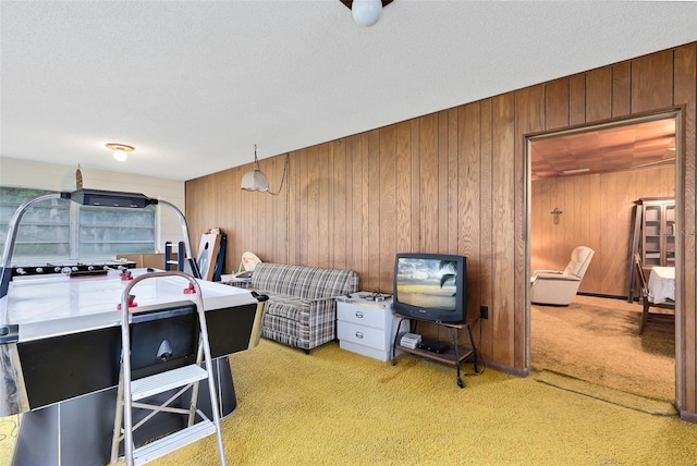 bedroom featuring wooden walls, a textured ceiling, and light colored carpet