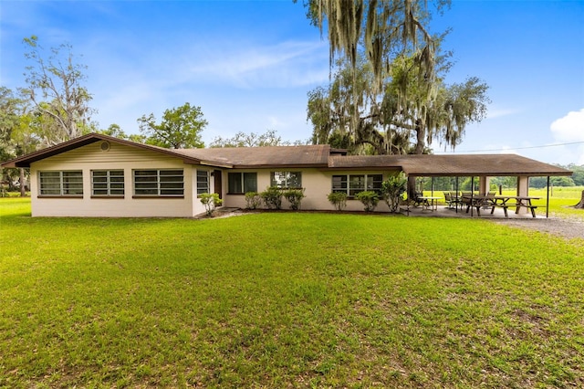 rear view of house featuring a patio and a yard