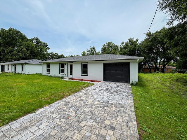 single story home with a garage and a front lawn