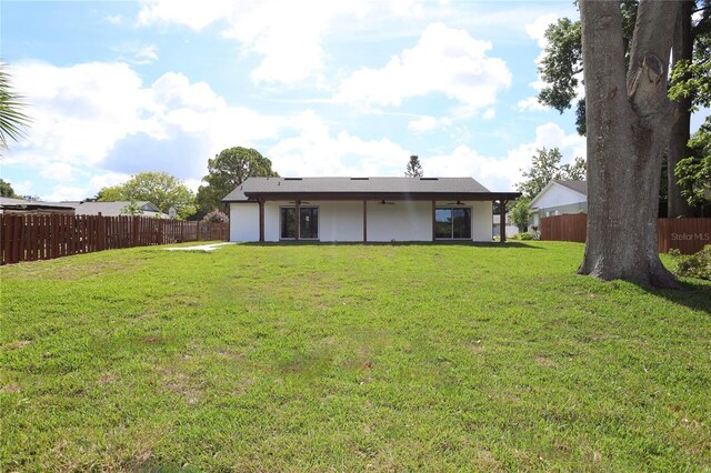 rear view of house featuring a lawn