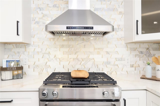 kitchen with white cabinets, stove, backsplash, and range hood