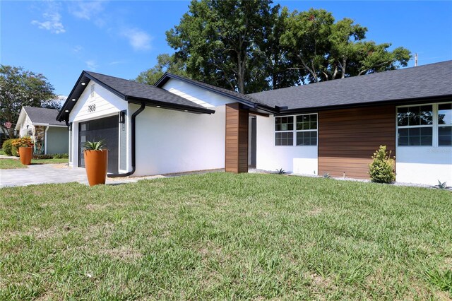 ranch-style house featuring a front yard and a garage