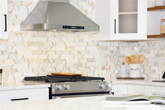 room details featuring backsplash, white cabinetry, ventilation hood, and gas stove