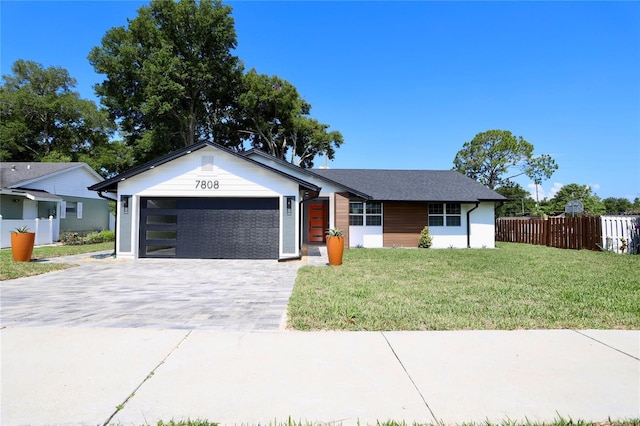 single story home featuring a front lawn and a garage