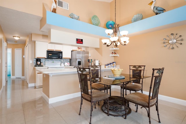 dining space featuring a towering ceiling, light tile flooring, and a chandelier