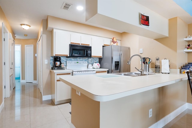 kitchen with white cabinetry, stainless steel fridge, backsplash, white range with electric stovetop, and sink