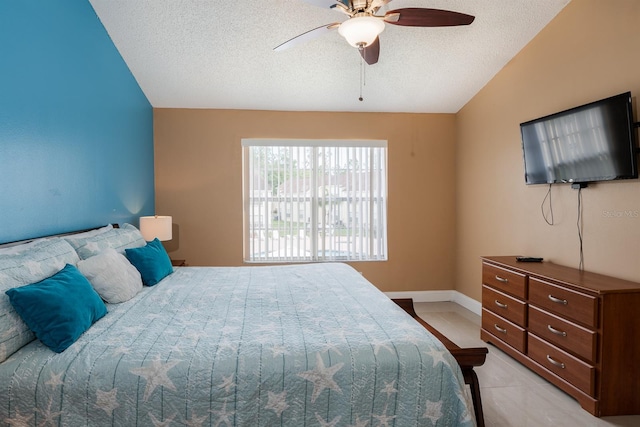 bedroom with ceiling fan, light tile flooring, a textured ceiling, and lofted ceiling