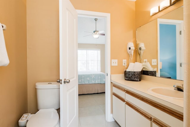 bathroom with ceiling fan, tile flooring, vanity with extensive cabinet space, and toilet