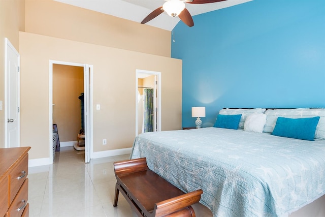 tiled bedroom featuring ensuite bathroom, a high ceiling, and ceiling fan