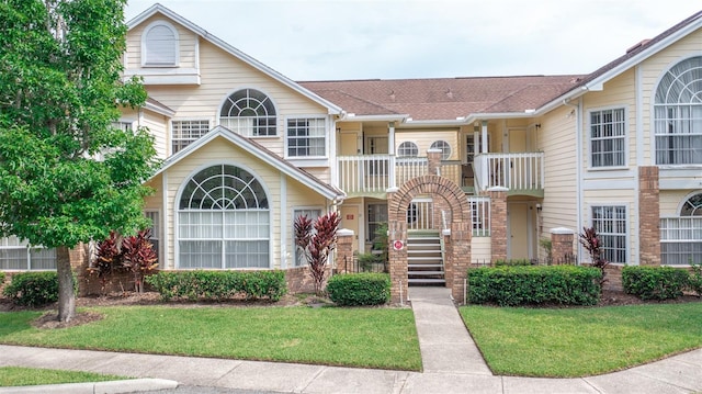 view of front facade featuring a front yard and a balcony