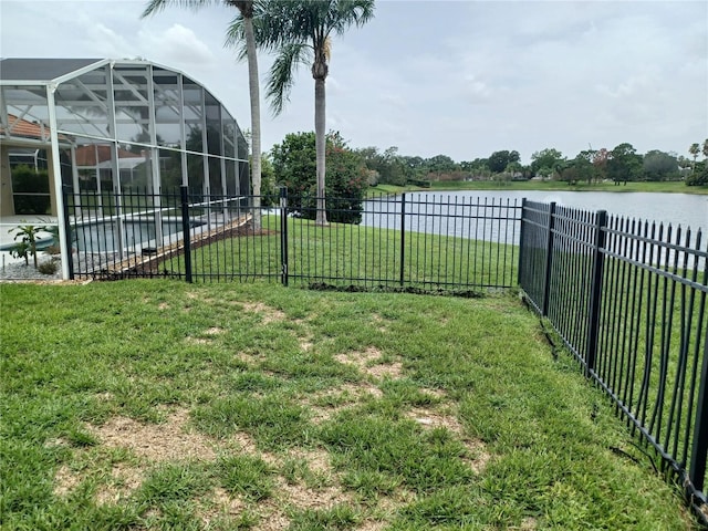 view of yard with a lanai and a water view