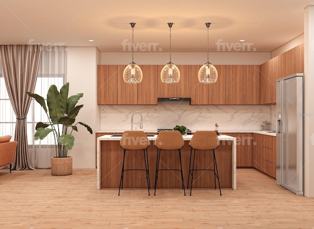 kitchen featuring pendant lighting, high quality fridge, a breakfast bar area, and decorative backsplash